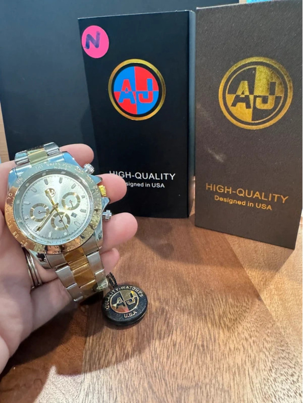 AJ stainless steel watch, gold & silver toned band.